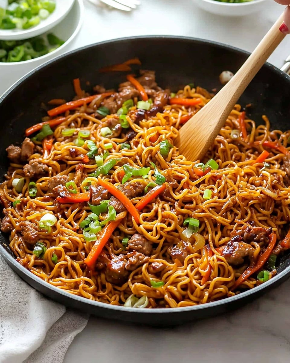 A large black pan filled with cooked curly noodles mixed with small pieces of brown meat, thin orange carrot strips, and bright red bell pepper slices. The noodles and vegetables have a shiny, slightly oily texture, and the dish is topped with fresh green chopped spring onions scattered evenly. Two wooden spoons rest in the pan, one being held by a woman's hand, stirring the noodles. The pan is placed on a white marbled surface with white bowls and some silver forks in the background. photo taken with an iphone --ar 4:5 --v 6.1