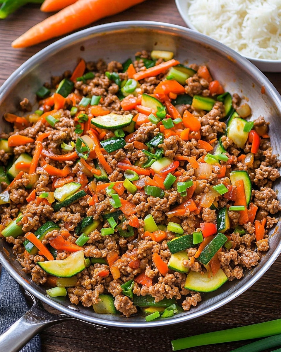 A white bowl is filled with a base layer of fluffy white rice, topped with a colorful mixture of cooked ground meat and vegetables including diced red bell peppers, sliced green zucchini, and finely chopped orange carrots. The top is garnished with small slices of fresh green onions. In the background, there is a white bowl with more of the meat and vegetable mix. The bowls are placed on a wooden table with fresh carrots, spring onions, and fresh ginger root on the side, along with a blue and white checkered cloth. Two silver forks rest on the table near the bottom right corner. The photo taken with an iphone --ar 4:5 --v 6.1