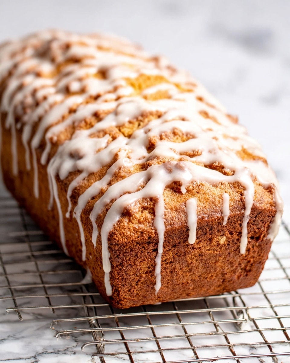 A close-up of two slices of cinnamon swirl bread placed on a cooling rack over a white marbled surface. Each slice has a golden-brown color with a darker, textured swirl of cinnamon running through the middle, creating a spiral pattern in the soft, crumbly texture of the bread. The top edges of the slices show a slight crust with hints of sugar glaze. One slice is fully visible in the center of the frame, while the other is partially shown on the right side. Photo taken with an iphone --ar 4:5 --v 7