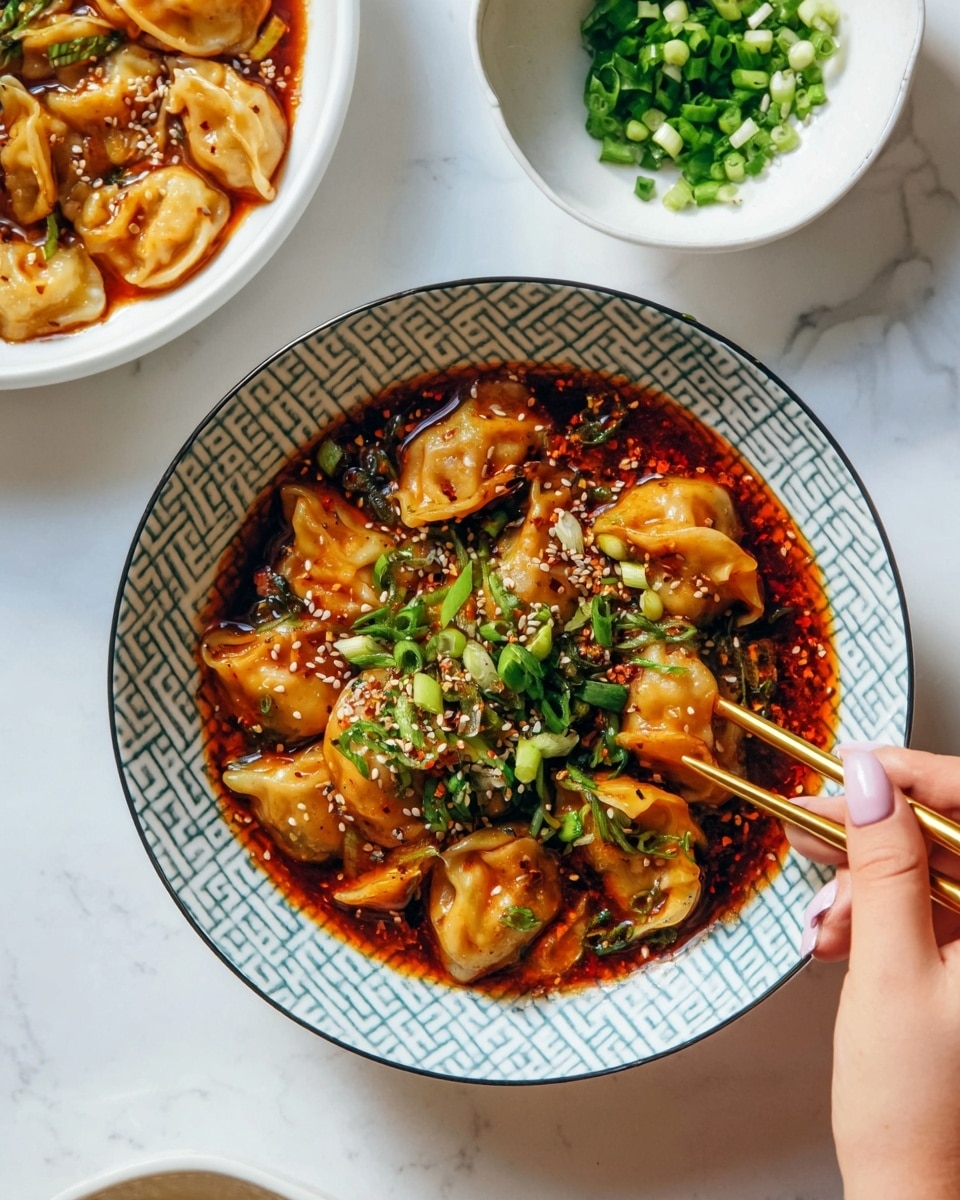 A bowl filled with around fifteen plump, golden-brown dumplings in a shiny, rich reddish-brown sauce that has visible chili flakes and sliced mushrooms mixed through. The dumplings are topped with a sprinkle of white sesame seeds and chopped bright green scallions, adding a fresh contrast. The bowl has a geometric, light blue and white pattern and is held by a woman's hand with light pink nails holding a pair of golden chopsticks near the rim. There are two other bowls present nearby: one white bowl partially filled with more dumplings and sauce, and another smaller white bowl with extra chopped scallions and sesame seeds, all set on a white marbled surface. photo taken with an iphone --ar 4:5 --v 7