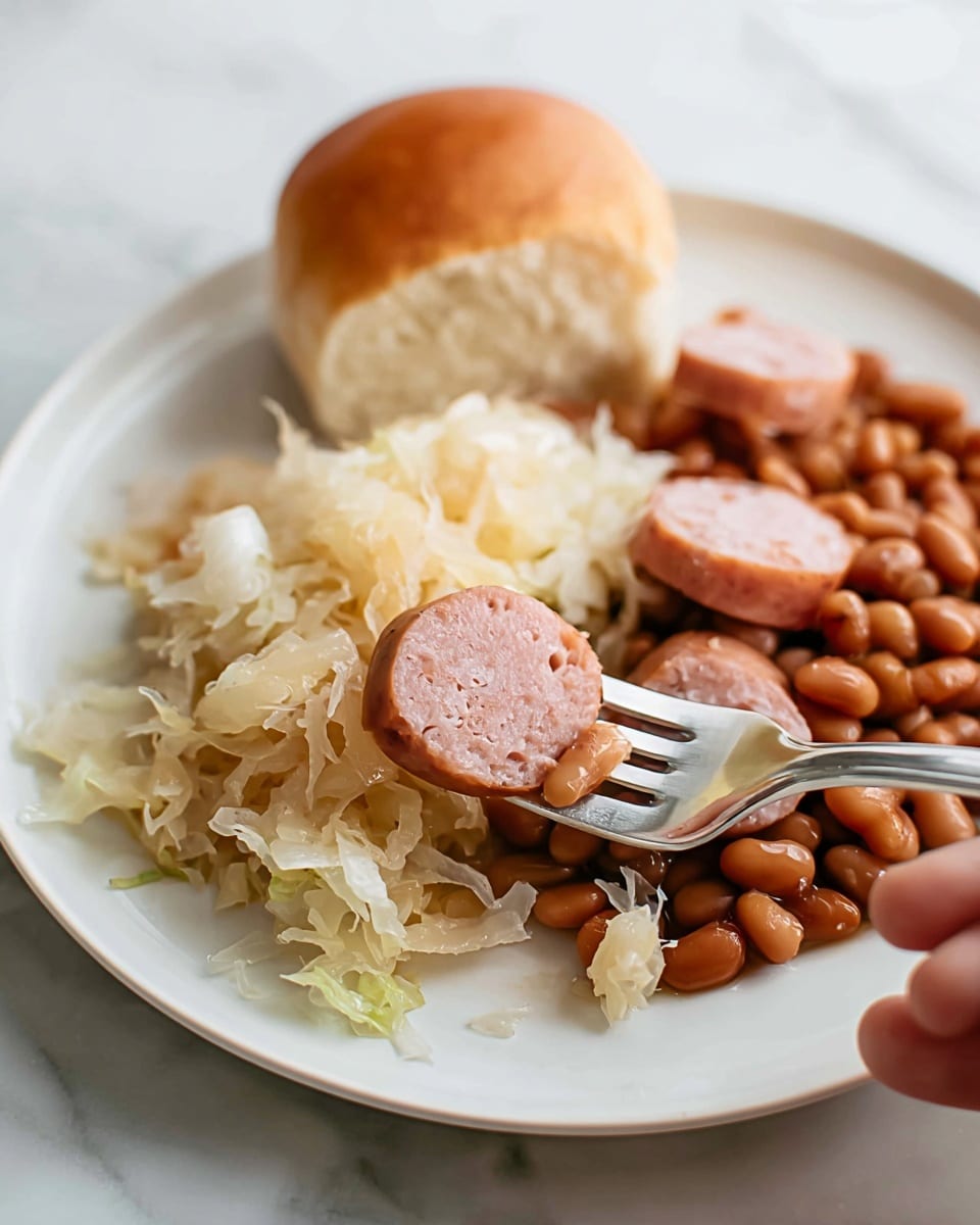 A white plate on a white marbled surface holds three food parts: a round cornered light brown bread roll at the back left, a heap of pale yellow shredded sauerkraut mixed with several slices of pink sausage with smooth skin in the front, and a pile of cooked brown beans on the back right. A silver fork, held by a woman's hand, takes a bite with a sausage slice and sauerkraut from the front pile. The scene is softly lit and close-up, showing textures clearly. Photo taken with an iphone --ar 4:5 --v 7