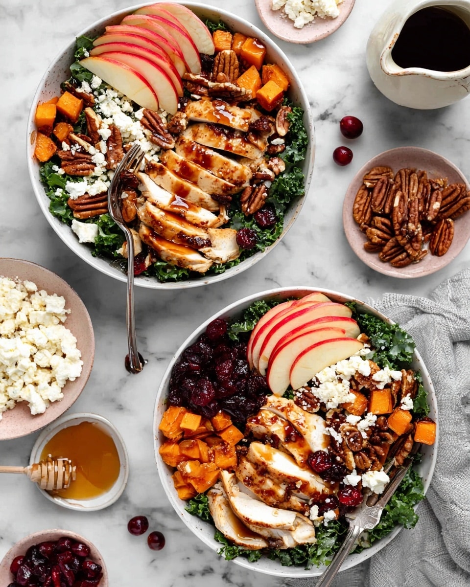 The image shows two white bowls filled with layers of food on a white marbled surface. The bottom layer in each bowl is dark green kale. On top of the kale, there are thinly sliced red apple pieces arranged on one side. Next to the apples, cooked and sliced chicken is placed in medium thick strips with a golden brown sear. Scattered around the bowl are small cubes of orange sweet potatoes, dried red cranberries, and whole pecans. Crumbled white cheese is sprinkled on top of everything. A dark balsamic glaze is drizzled over the chicken and some other ingredients. Each bowl has a silver fork resting inside. Around the bowls are extra pecans, dried cranberries in a small pink dish, crumbled cheese on a small plate, a white jug with balsamic glaze, and a small white bowl holding honey and a honey dipper. Photo taken with an iphone --ar 4:5 --v 7