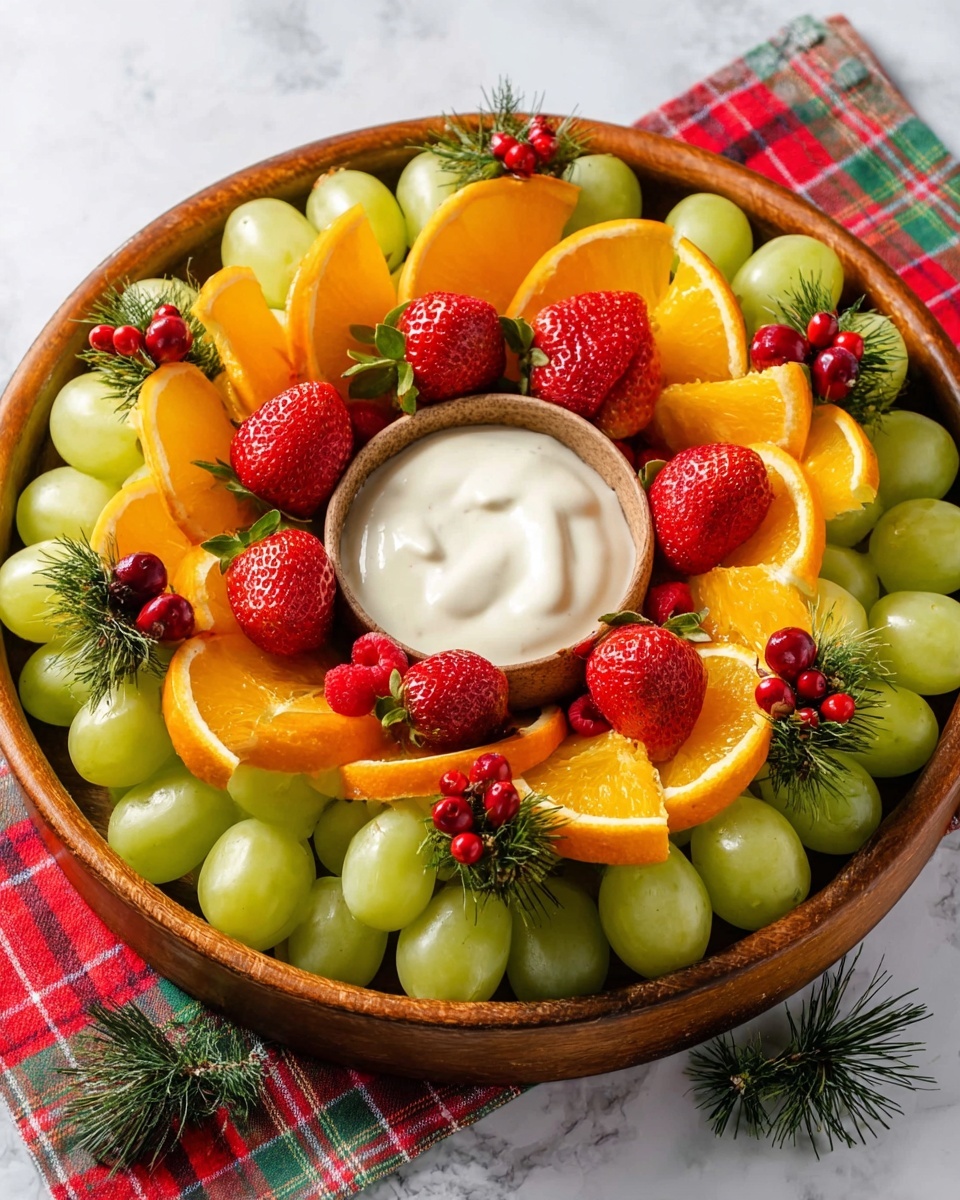A round wooden tray holds a colorful fruit arrangement on a white marbled surface with a red and green plaid cloth underneath. In the center, there is a small round dish filled with smooth, white creamy dip. Surrounding the dish is a thick layer of green grapes with shiny skins, interspersed with bright red strawberries, some whole and some with green tops visible. There are also orange slices, each cut into wedges, positioned upright around the inner circle to form a petal-like structure, with small red raspberries placed carefully inside the orange wedges. Small sprigs of green pine with red berries are placed around the outer edges, adding a festive touch. The overall look is fresh, vibrant, and neatly arranged. photo taken with an iphone --ar 4:5 --v 7