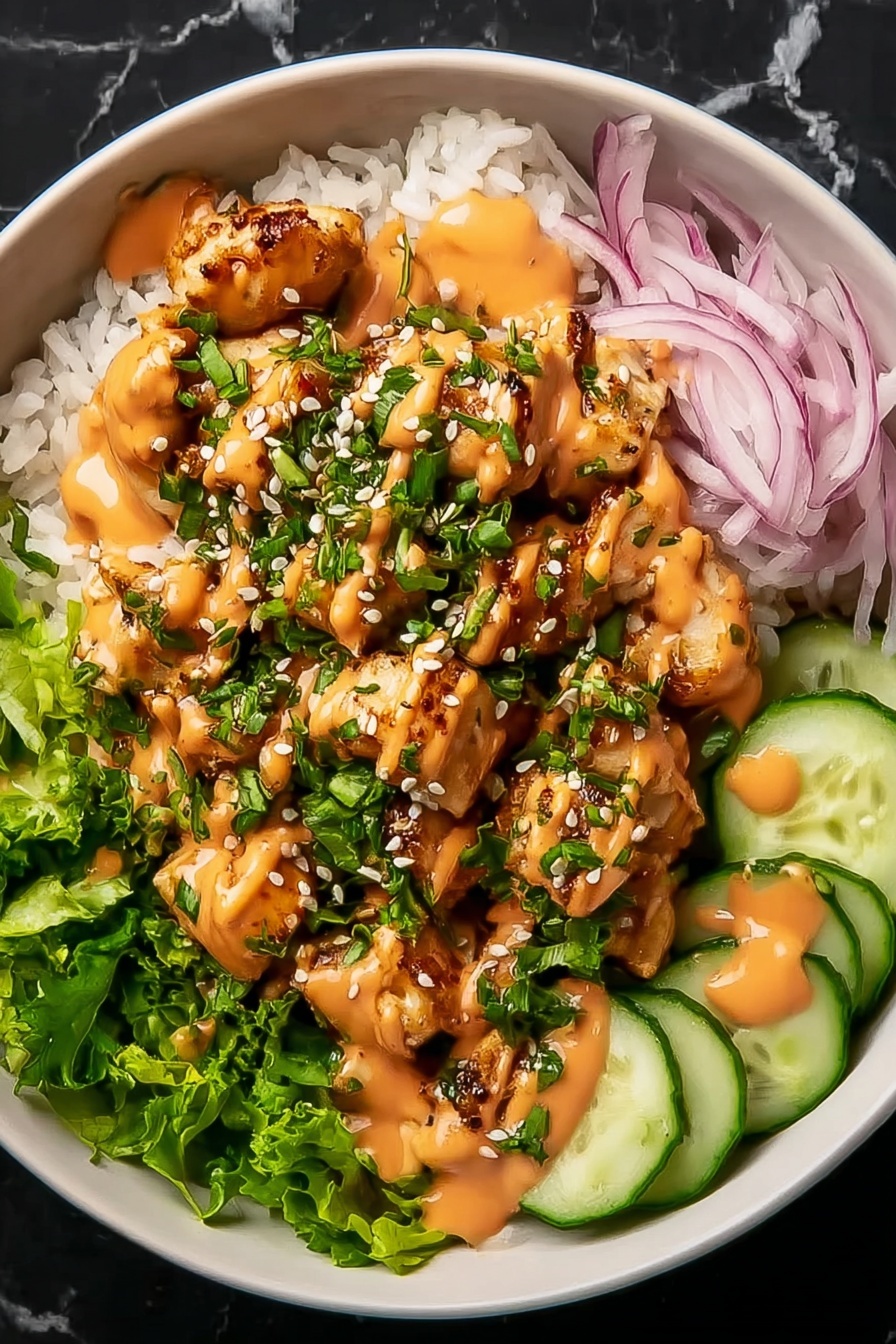 A bowl with a base layer of white rice topped with chopped green lettuce and thinly sliced red onions on one side. Small, golden-brown grilled chicken pieces are placed in the center, covered with green chopped herbs and white sesame seeds. On the right side, there are thin, round cucumber slices. The dish is drizzled with an orange creamy sauce over the chicken and cucumbers. The bowl is white and set on a white marbled surface. Photo taken with an iphone --ar 2:3 --v 7 - Bang Bang Chicken Bowl, Chicken Bowl Recipe, Easy Weeknight Dinner, Crispy Chicken and Veggie Bowls, Spicy Chicken Rice Bowl