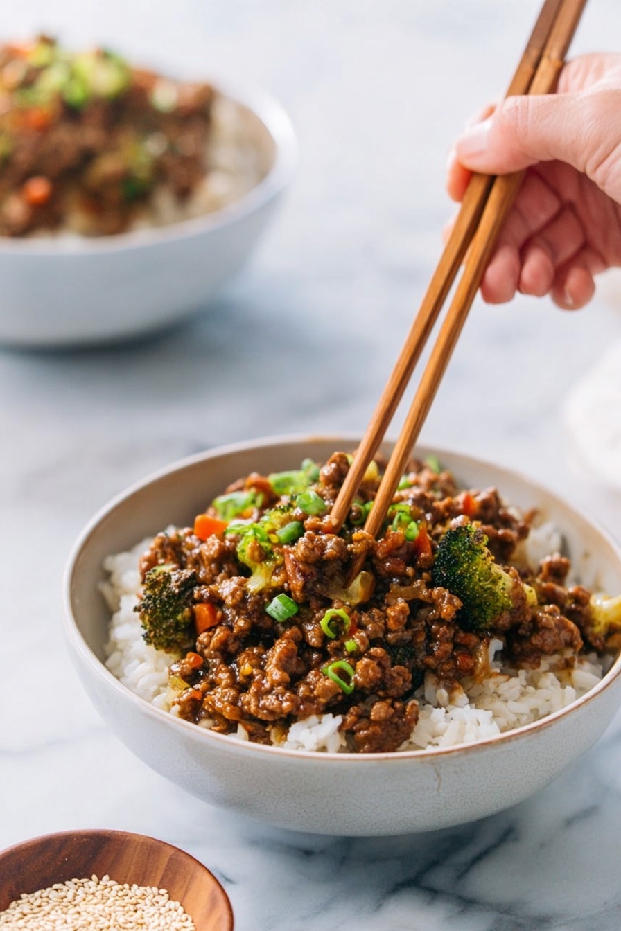 A white bowl filled with two main layers: the bottom layer of soft, white rice with a slightly fluffy texture and the top layer of cooked minced meat mixed with small broccoli pieces, finely chopped carrots, and green onions, all coated in a rich brown sauce with a glossy finish. A woman's hand is using wooden chopsticks to pick up some of the meat and vegetables, with a small brown bowl of white sesame seeds visible in the background on a white marbled surface. Another bowl with a similar meal is out of focus behind. Photo taken with an iphone --ar 2:3 --v 7 - Teriyaki Ground Turkey Bowl, healthy turkey dinner, easy weeknight dinner, quick ground turkey recipes, flavorful Asian-inspired bowls